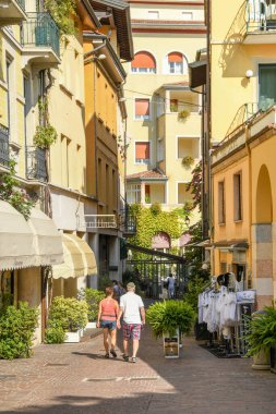 GARDON RIVIERA, İtalya - Eylül 2018 Garda Gölü 'ndeki Gardone Riviera' da dar bir sokakta yürüyen iki kişi.