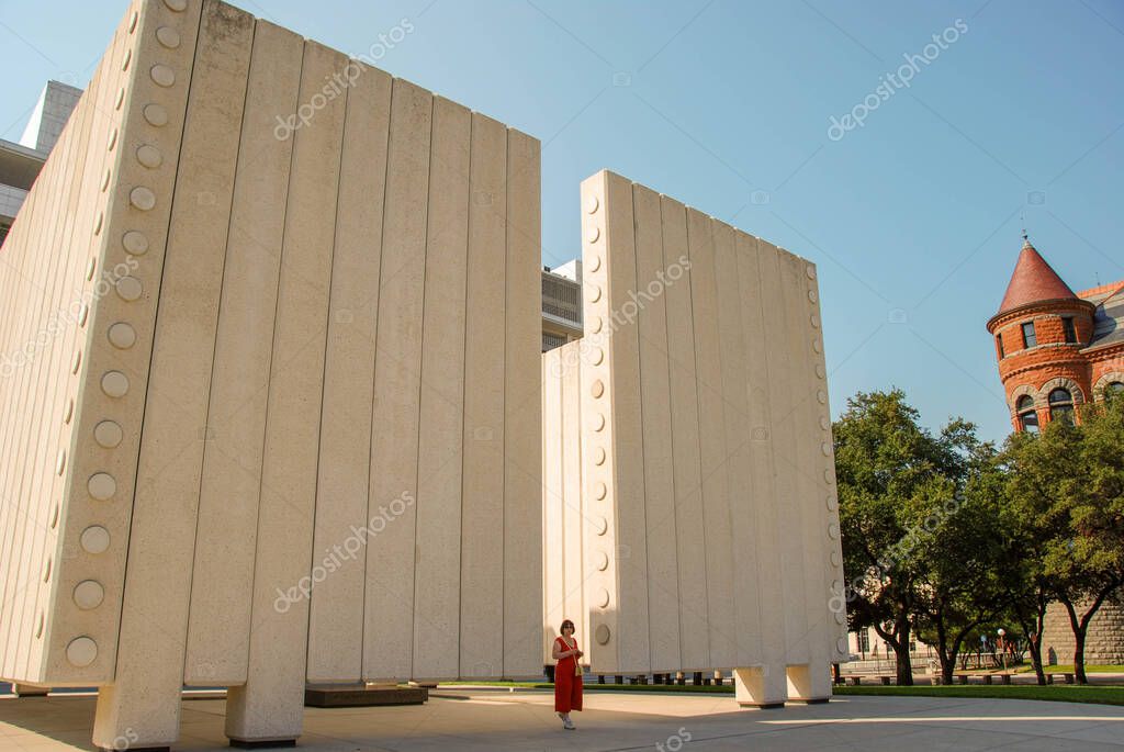 Dallas, Texas - September 2009: Wide angle view of the memorial to President John F Kennedy in the West End Historic District with a person beside it for scale