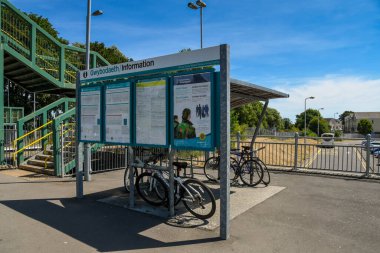 Llantwit Major, Glamorgan, Galler 'den Vale - Temmuz 2018: Llantwit Major tren istasyonunun girişinde zaman balyası duyuru tahtası ve bisiklet depolama sığınağı