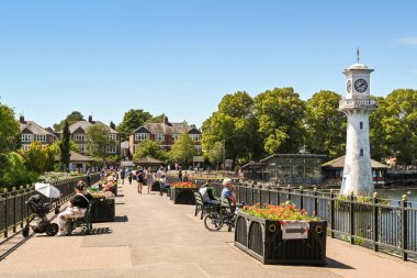 Cardiff, Wales - Temmuz 2020: Cardiff 'teki Roath Park Gölü' nde oturma alanı ve saat kulesi. Saat, Cardiff 'ten 1910' da Antartik 'e giden Kaptan Scott için bir anıttır..