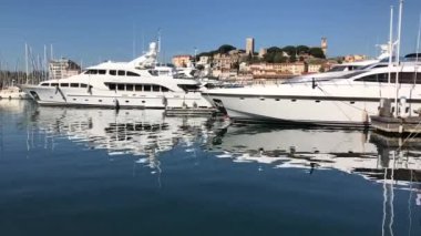 Cannes, FRANCE - 2019: lüks motorlu yatlar Fransız Rivierası 'ndaki Cannes limanında durgun su ve yansıma ile rıhtıma yanaştı