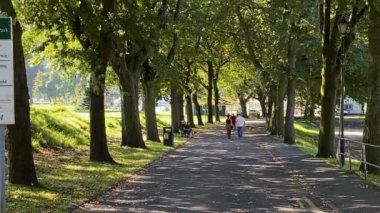 Pontypridd, Wales Eylül 2020: Pontypridd şehir merkezindeki halk parkında ağaçlık bir yolda yürüyen insanlar. Uzaklaştır