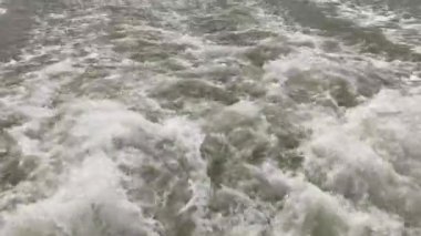 Nehirdeki bir feribotun ardından akan sular.