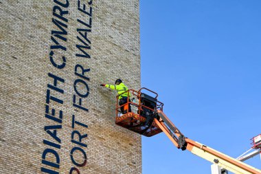 Pontypridd, Galler Eylül 2020: Kiraz toplayıcı hidrolik platformunda çalışan kişi yeni bir ofis geliştirme alanında çalışıyor