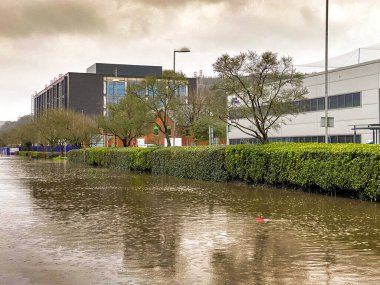NANTGARW, NEAR CARDIFF, WALES - FEBRUARY 2020: Flooded road outside offices on Treforest Industrial Estate near Cardiff clipart