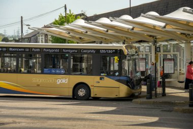 Pontypridd, Galler - Mayıs 2018: Pontypridd 'in şehir merkezindeki otobüs durağında yolcu bekleyen bir Posta Arabası Altın Otobüsü