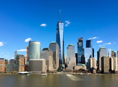 New York, ABD - Nisan 2017: Aşağı Manhattan silueti derin mavi bir gökyüzünün altında Hudson nehrinin sularına ışık akışını yansıtan ünlü bir binayı gösteriyor