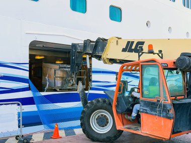 Acapulco, Meksika - 15 Ocak 2024: Bir yük dolusu yiyecek ve içeceği bir yolcu gemisine yükleyen bir çatal kaldırma aracının görüntüsü