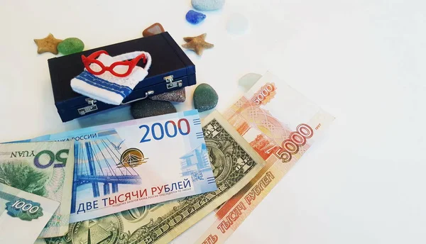 Het geld voor de reis is onder de koffer. Bankbiljetten van verschillende landen. — Stockfoto