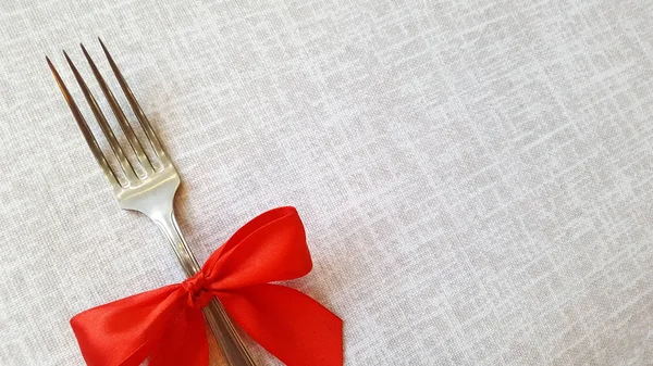 Festive table decoration. Fork with a red bow.. Empty space to insert text.  Photo for the menu of cafe, restaurant, dining room, pizzeria. A place for a festive menu. — Stock Photo, Image