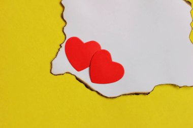 İki kırmızı kalp beyaz yanmış kağıt parçası üzerinde yalan. aşk kavramı.