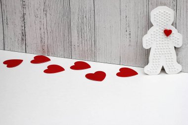 Beyaz bir arka plan üzerinde kırmızı karton kalpleri vardır. Plastik Şekil kırmızı bir kalp ile bir adam. aşk kavramı. Sevgililer günü. Kopya alanı.