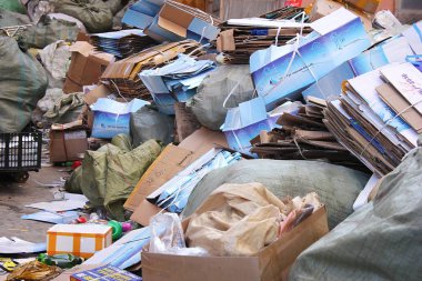 Karton kutular ve çöp torbası içinde büyük bir yığın Kazıklı. Şehrin çöplüğü.