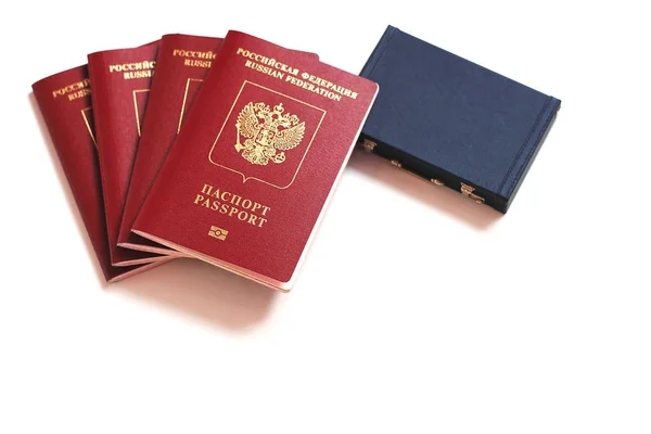 Het paspoort van de Russische Federatie. Biometrische Russische paspoorten zijn aying rond een miniatuur koffer op een witte achtergrond. — Stockfoto