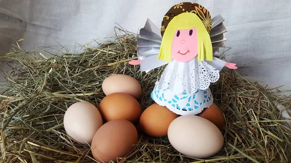 Eggs in a nest with an angel figure. Happy easter