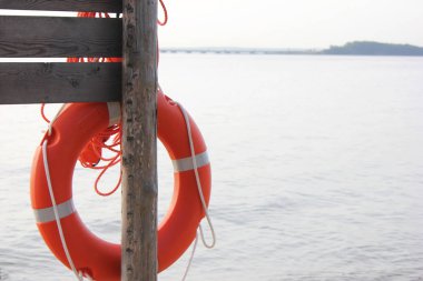 Sahilde denize yakın ahşap bir yapı üzerinde asılı Turuncu cankurtaran