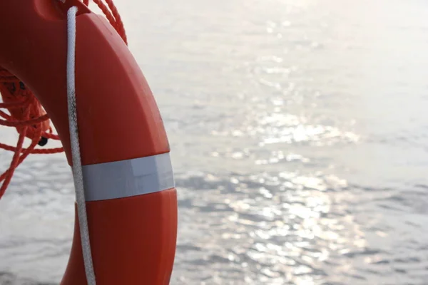 Orange lifeline hanging near the sea on the beach — Stock Photo, Image