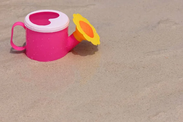 바다 해안의 모래에 장난감 급수 수. — 스톡 사진