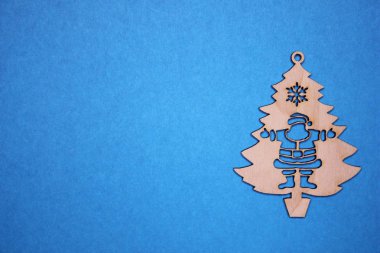 Mavi bir arka plan üzerinde Noel Baba ile Ahşap Noel ağacı heykelcik.