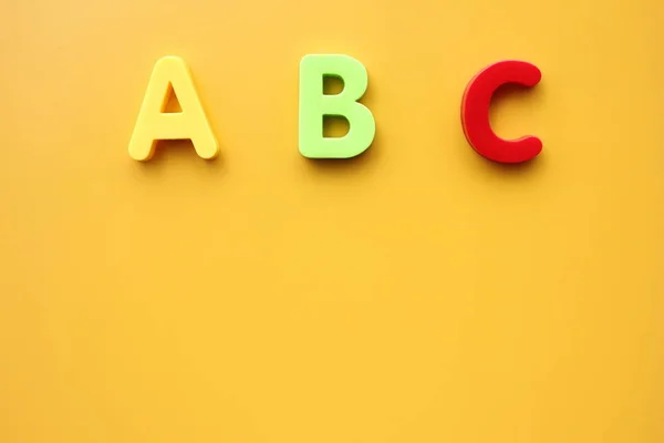 ABC prime lettere dell'alfabeto inglese su sfondo giallo. Spazio vuoto per il testo . — Foto Stock