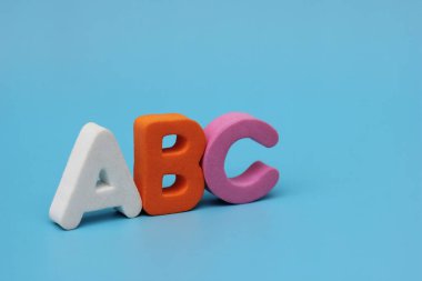 ABC 'nin renk harfleri mavi arka planda izole edilmiştir. Yabancı dil öğreniyorum. Yeni başlayanlar için İngilizce.