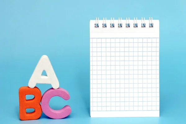 ABC-the first letters of the English alphabet on a blue background. Empty space for text. Blank Notepad page