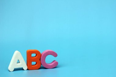 ABC 'nin renkli harfleri mavi arka planda izole edilmiştir. Yabancı dil öğreniyorum. Yeni başlayanlar için İngilizce. Boşluğu Kopyala.
