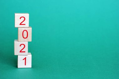 2021 sayıları bir piramidin içinde üst üste duran tahta blokların üzerinde. Yeni yıl 2021 konsepti.