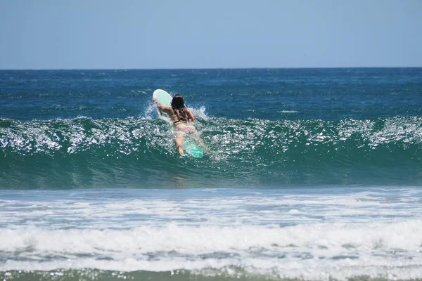 Ung kvinna surfing i Nicaragua. — Stockfoto