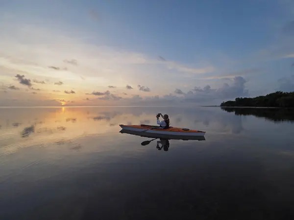 Kobieta, spływy kajakowe o wschodzie słońca w Bear Cut, Florida. — Zdjęcie stockowe