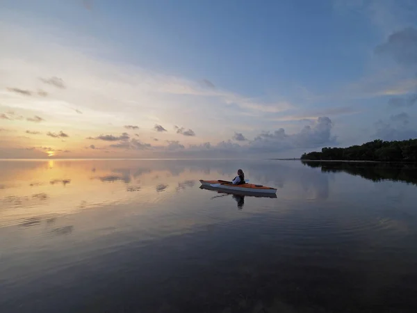 Vrouw bij zonsopgang in Bear Cut, Florida kayaking. — Stockfoto