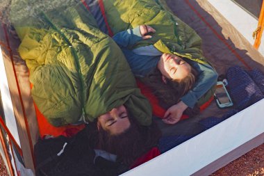 Two sisters asleep in their tent in the Grand Canyon. clipart