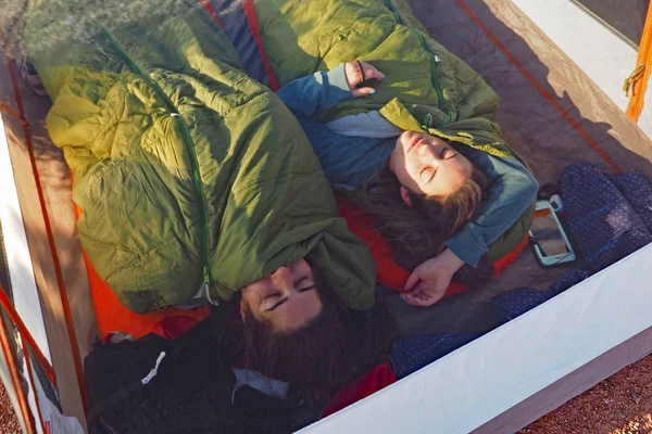 Two sisters asleep in their tent in the Grand Canyon.