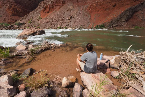 Молодая женщина отдыхает у реки Колорадо в Гранд-Каньоне . — стоковое фото
