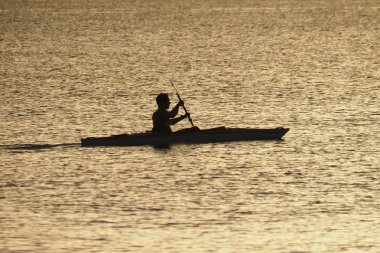 Genç adam gün batımında Captiva Adası 'nda Kano.