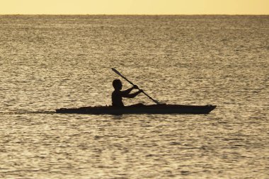Genç adam gün batımında Captiva Adası 'nda Kano.