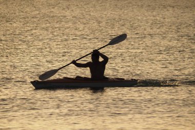 Genç adam gün batımında Captiva Adası 'nda Kano.
