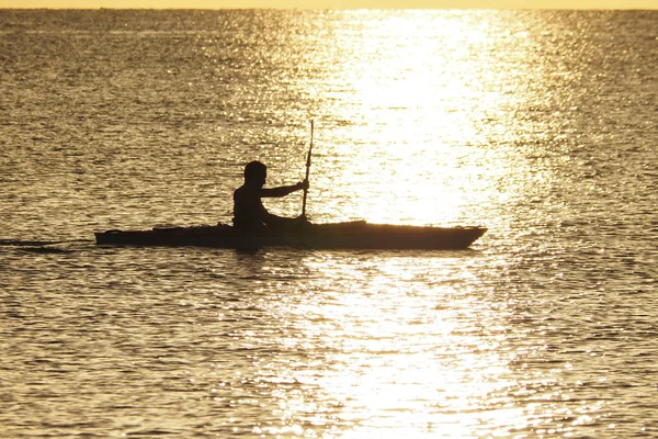 Junger Mann paddelt bei Sonnenuntergang vor Captiva Island. — Stockfoto