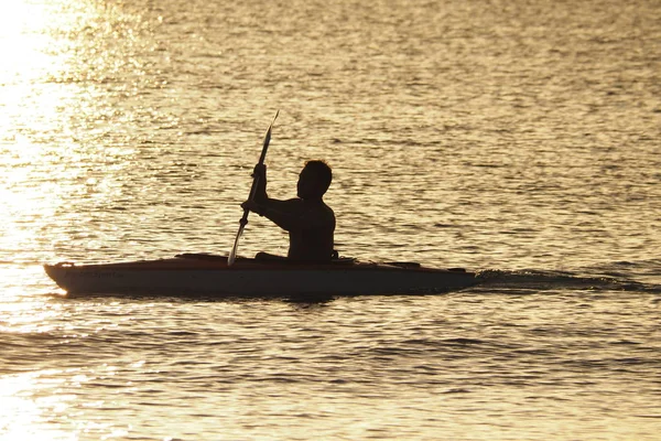 Genç adam gün batımında Captiva Adası 'nda Kano. — Stok fotoğraf