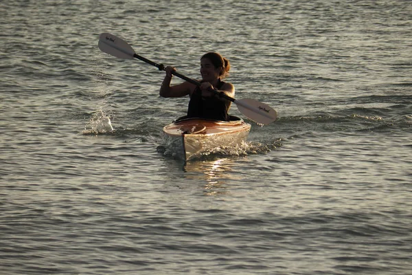 Young woman kayaking off Captiva Island at sunset. Royalty Free Stock Photos