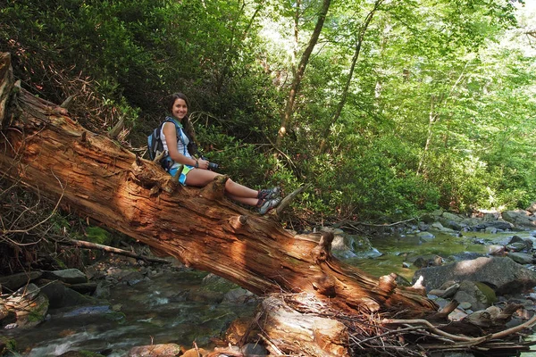 Jonge vrouw op de log door een Smoky Mountains kreek. — Stockfoto