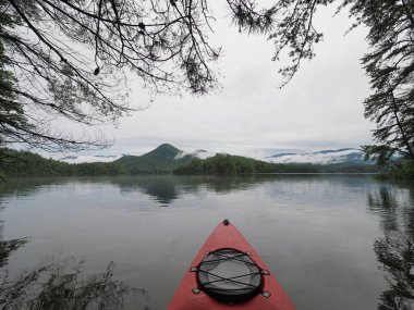 Santeetlah Gölü bulutlu bir sabah kırmızı kayık, Kuzey Carolina.