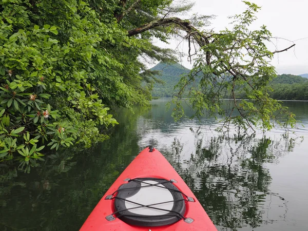 Santeetlah Gölü bulutlu bir sabah kırmızı kayık, Kuzey Carolina.
