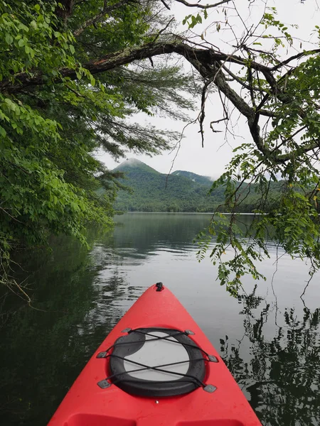 Santeetlah Gölü bulutlu bir sabah kırmızı kayık, Kuzey Carolina.
