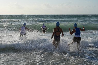 Kadın triatletler 2019 South Beach Triatlon başında sörf girin.