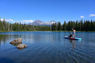 Scott Lake, Oregon üzerinde standup kürek kurulu iki genç kadın.