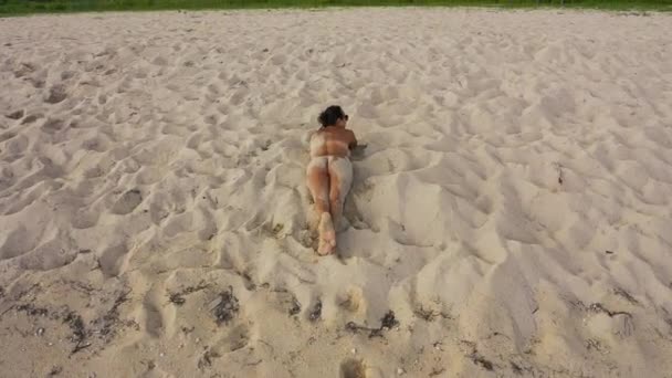 在巴厘岛海滩上 一个美丽的女孩日光浴 小行星 效果的无人机起飞 — 图库视频影像