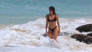 Güzel bir rakam ile Avrupa görünümlü esmer kız Bali Okyanusu dalgaları atlar