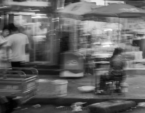 black and white photo of blurred people at the street