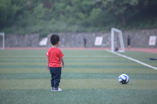 Asian small boy playing football